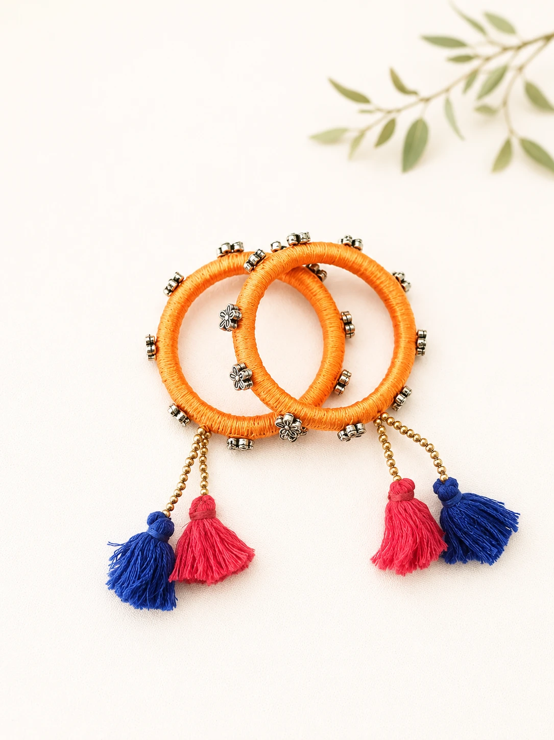 Handmade blue thread-wrapped tassel bangles set with yellow and pink tassel charms