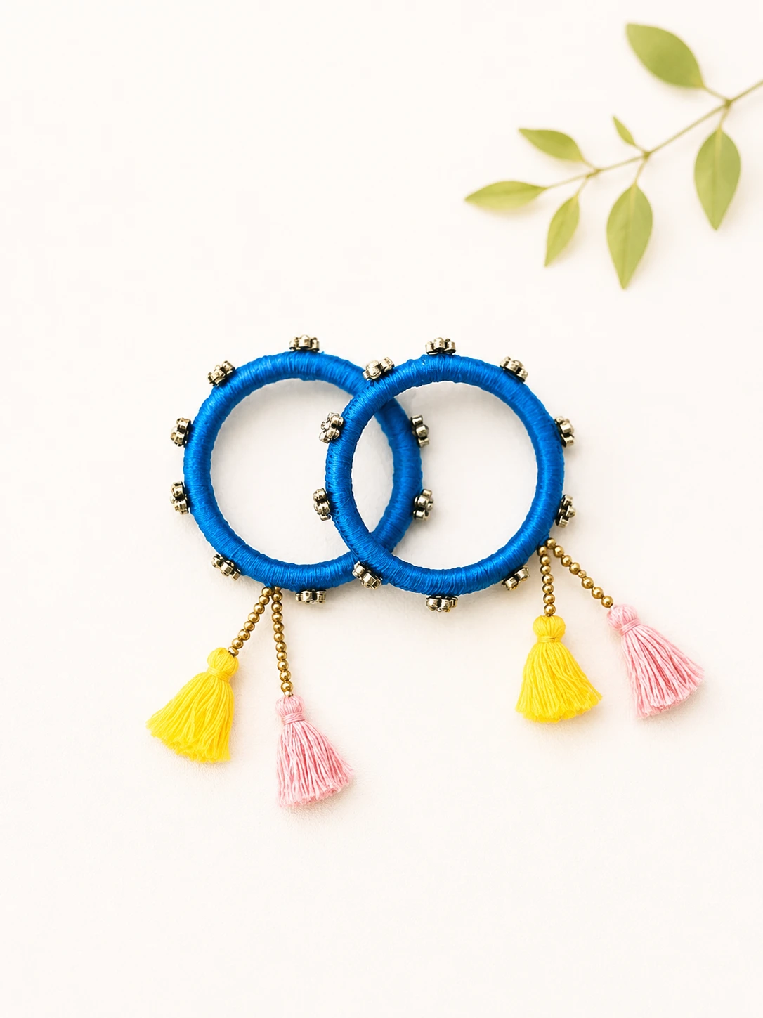 Handmade blue thread-wrapped tassel bangles set with yellow and pink tassel charms
