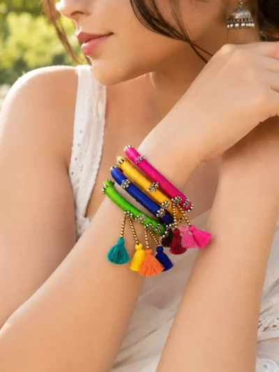 Handmade colorful thread work bangles set with tassel hangings and decorative metal embellishments for festive and ethnic wear.